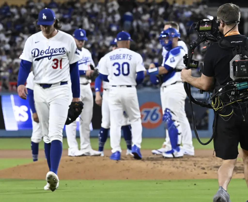 Dodgers starting pitcher Tyler Glasnow, left, walks off the field...