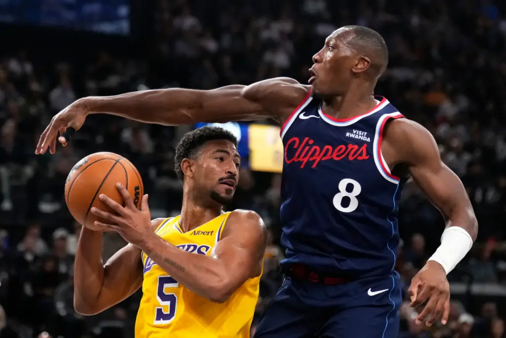Lakers guard Quentin Grimes, left, tries to pass the ball...