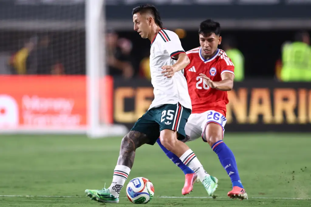 Mexico forward Roberto Alvarado, left, moves the ball as Chile...