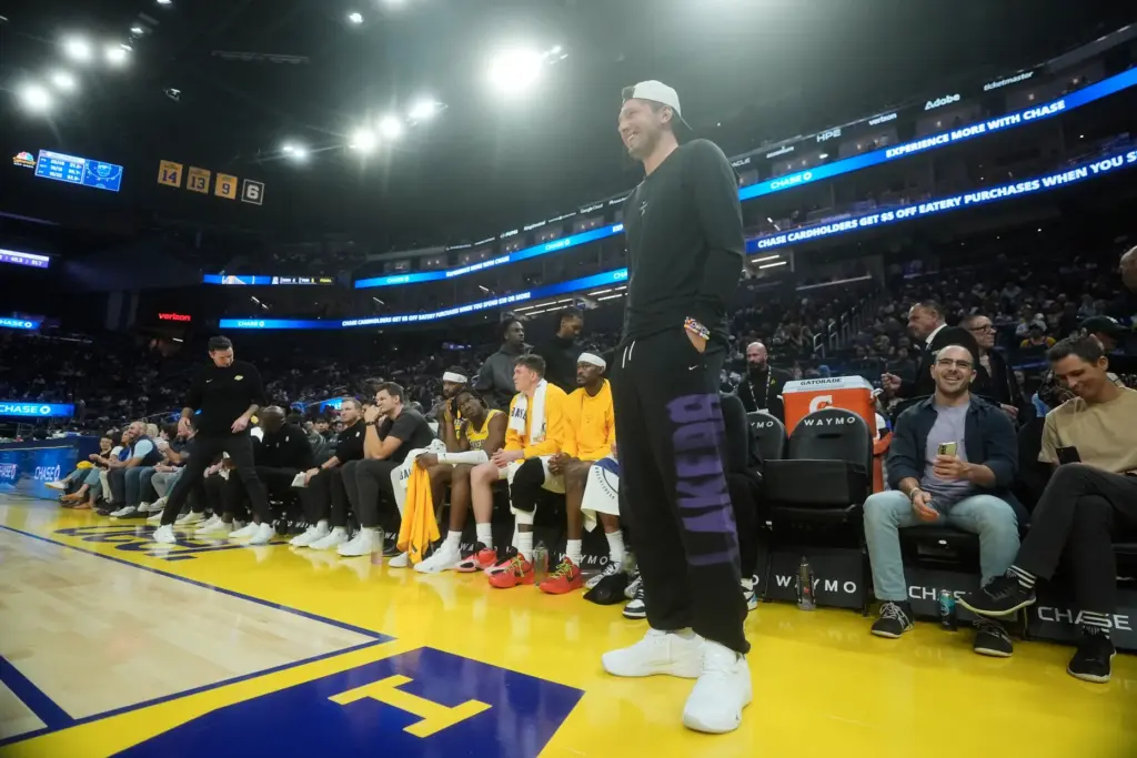 Lakers star Luka Doncic stands in front of the bench...