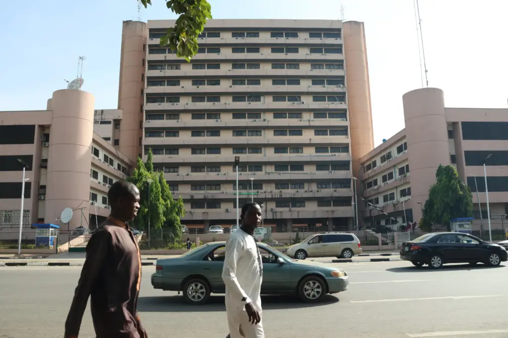 People walk past the Federal Ministry of Health in Abuja,...