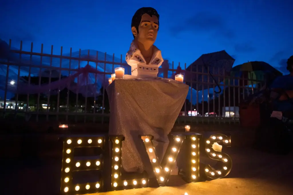 A street memorial is lit during a candlelight vigil for Elvis Presley in front of Graceland.