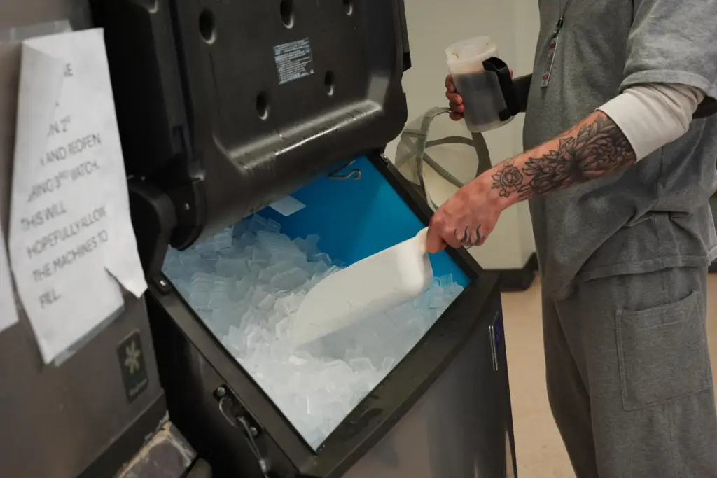 A person who is incarcerated scoops ice into his drink...