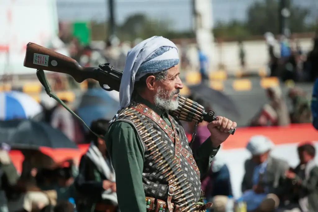 A supporter of Yemen’s Houthi rebels carries his rifle during...