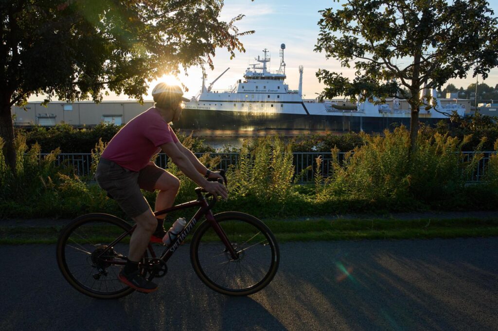 A cyclist bikes past the American Empress II, a trawler...