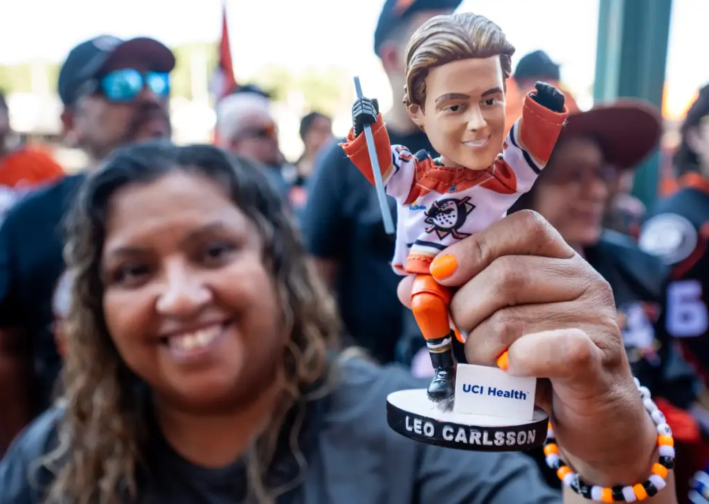 A Ducks fan holds up a bobble head of Leo...