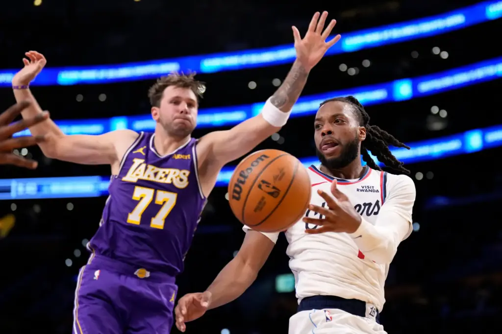 Clippers guard Darius Garland, right, passes the ball while under...