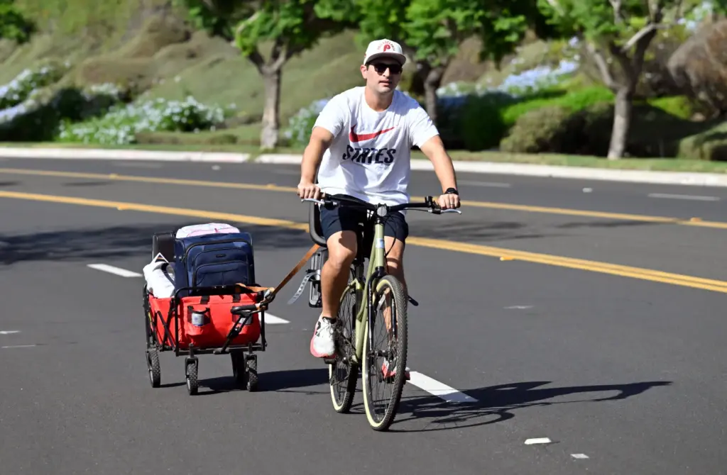 John Luca pulls his belongings in a wagon as he...