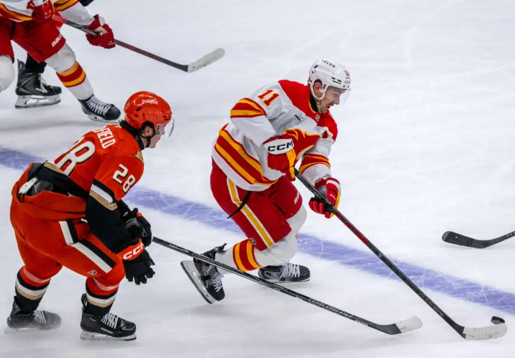 The Calgary Flames’ Mikael Backlund, right, controls the puck as...