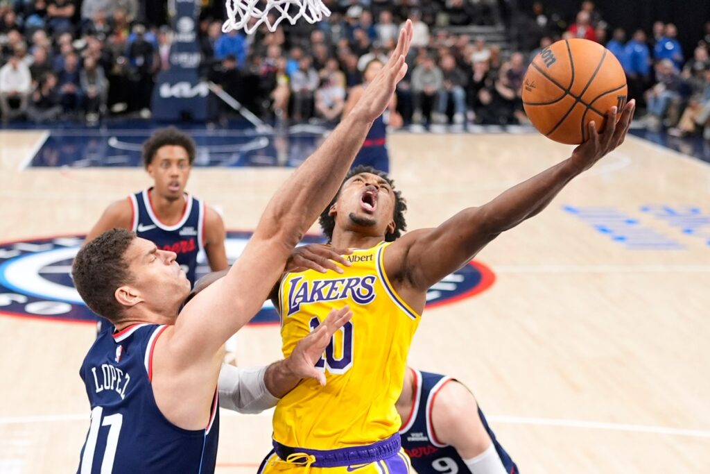 Lakers guard Collin Sexton, right, shoots as Clippers center Brook...