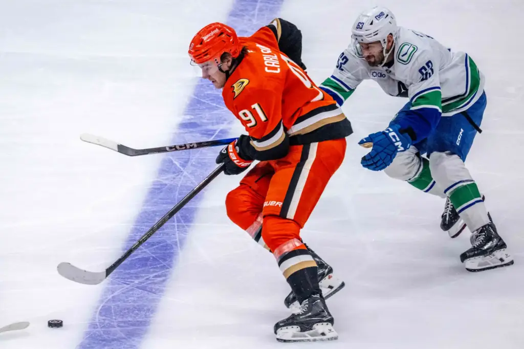 The Ducksâ Leo Carlsson, left, controls the puck as the...