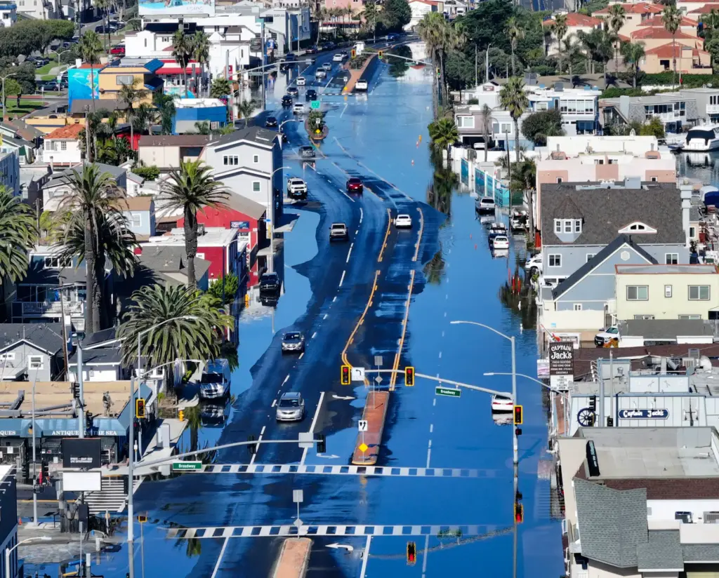 Sea water floods on to Pacific Coast Highway during high...