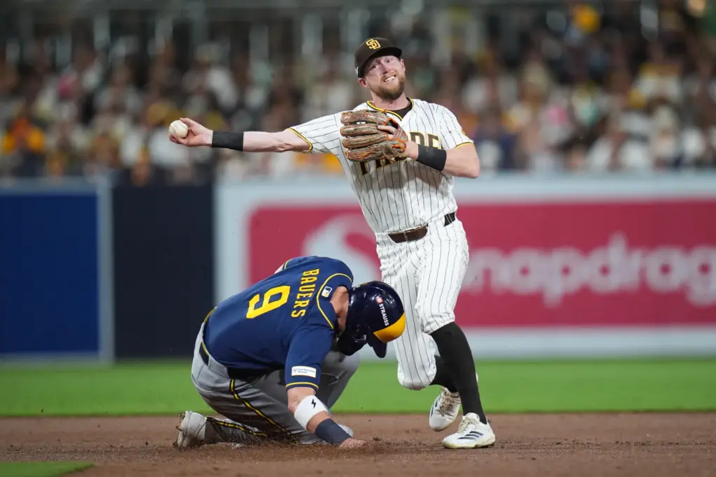 San Diego Padres second baseman Jake Cronenworth, top, throws to...