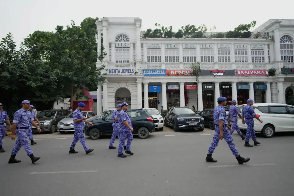 Security personnel patrol ahead of a tricolor (Indian flag) waving...