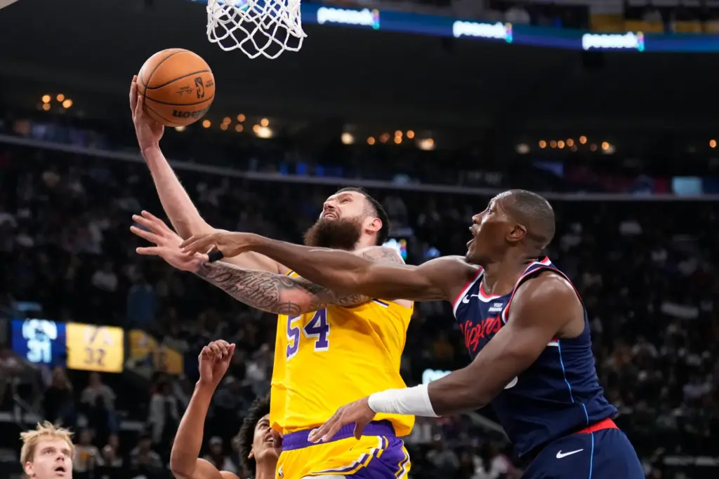 Lakers forward Sandro Mamukelashvili, left, shoots as Clippers guard Kris...