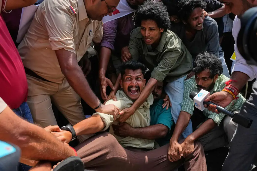 Socialist, left-wing parties and student activists shout slogans as police detain them.
