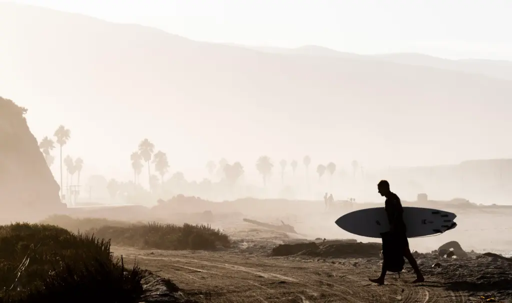A surfer comes out of the water at Lower Trestles...
