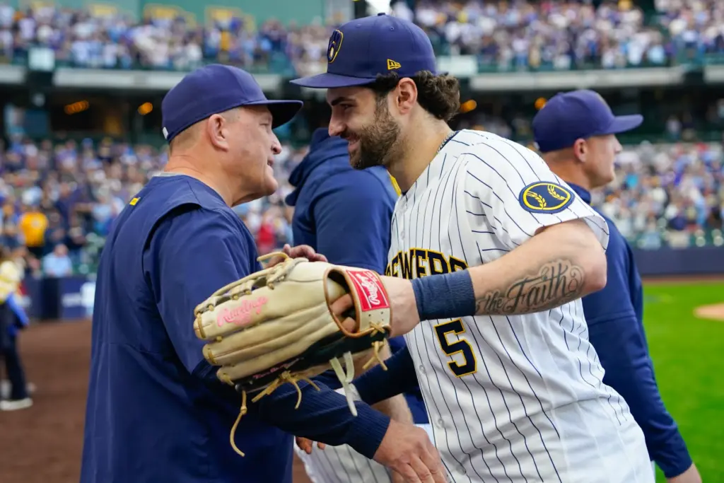 Milwaukee Brewers center fielder Garrett Mitchell, right, shakes hands with...