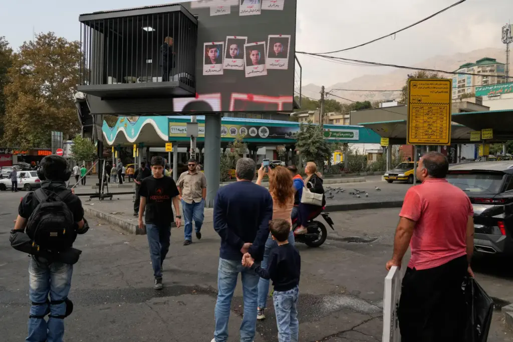 People look at a billboard installation featuring an actor portraying...