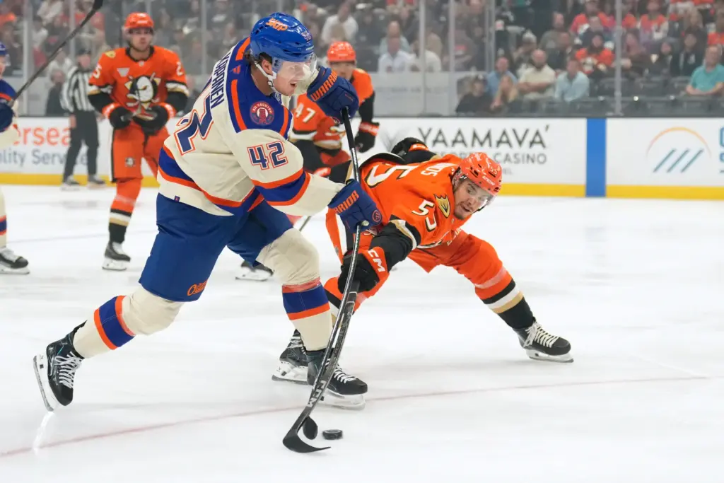 Edmonton Oilers right wing Kasperi Kapanen, left, passes the puck...
