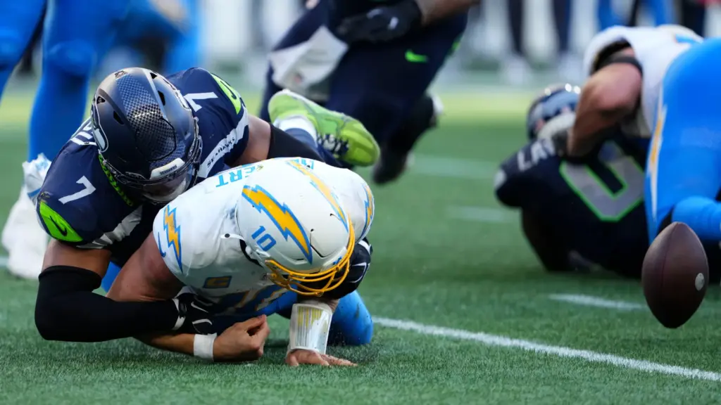 Chargers quarterback Justin Herbert (10) fumbles as he is tackled...