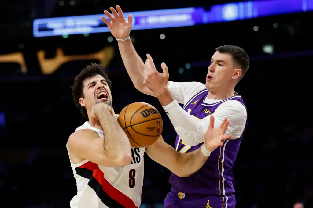 Portland Trail Blazers forward Deni Avdija, left, loses control of...