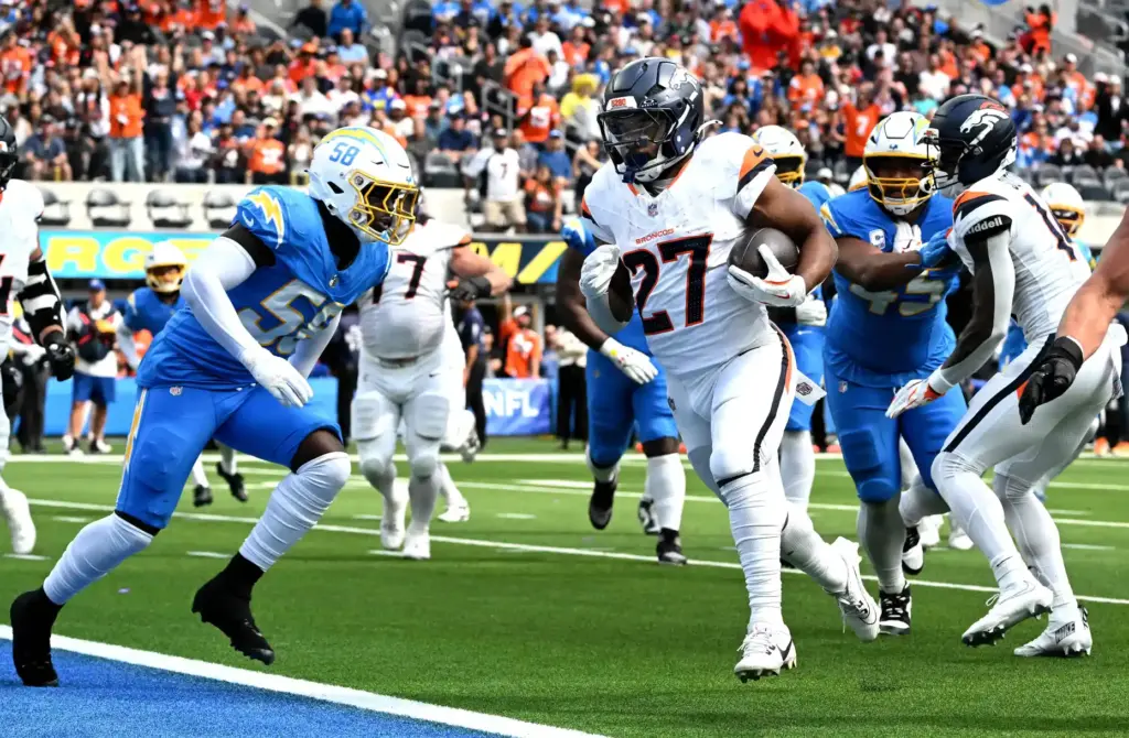 Denver running back J.K. Dobbins (27) scores on a short...