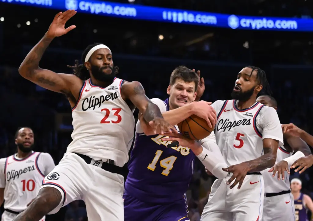 Lakers center Walker Kessler, middle, battles for the ball against...