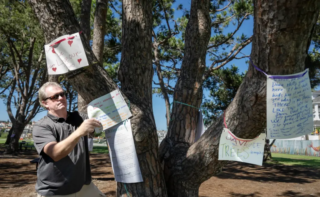 Gary Macrides and other Dana Point residents hang signs on...