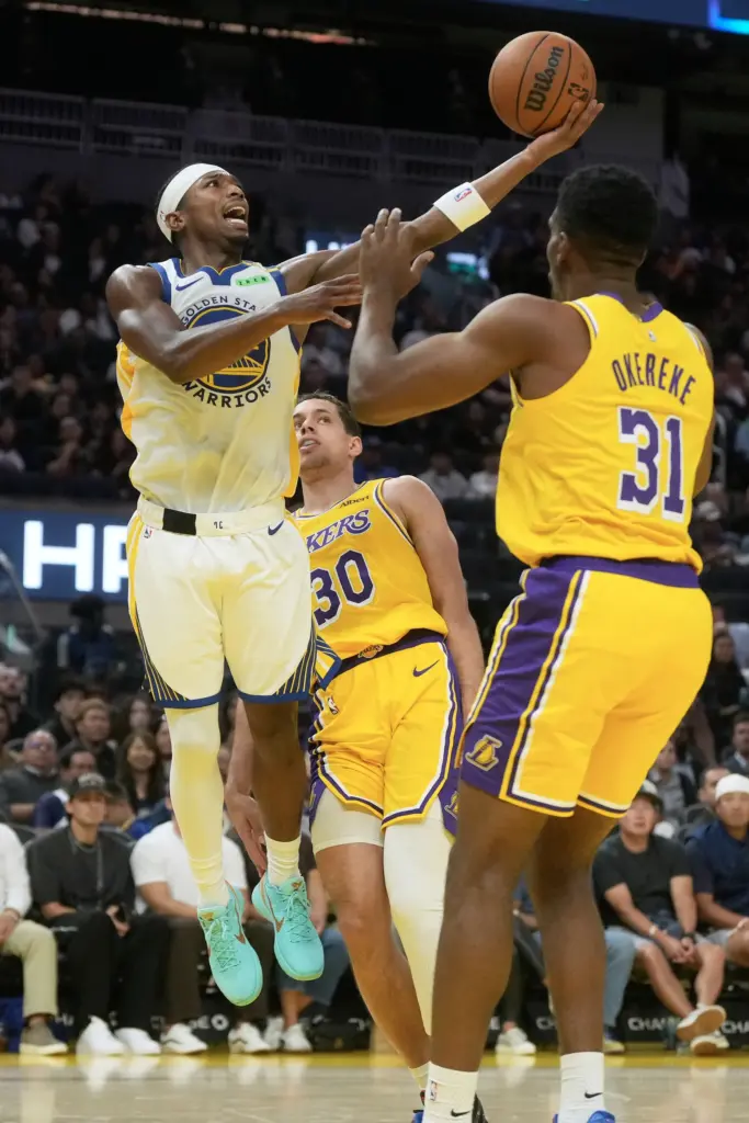 Golden State Warriors guard Brandon Williams, left, shoots as Lakers...