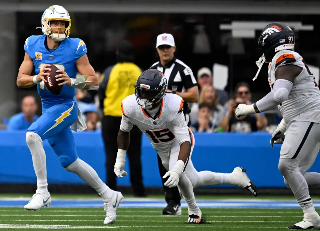 Chargers quarterback Justin Herbert (10) can not escape the grasp...