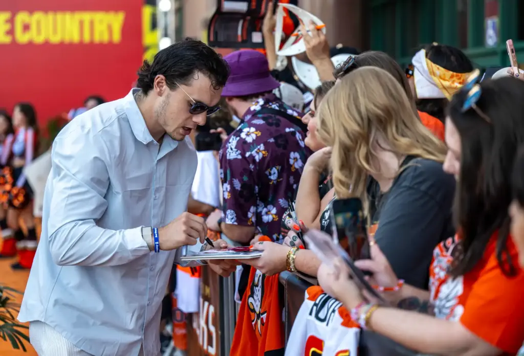 Ducks player Sam Colangelo signs autographs on the orange carpet...