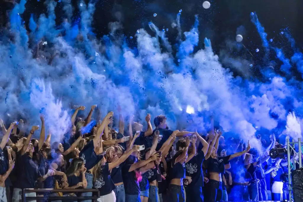 Newport Harbor students toss blue chalk into the air while...