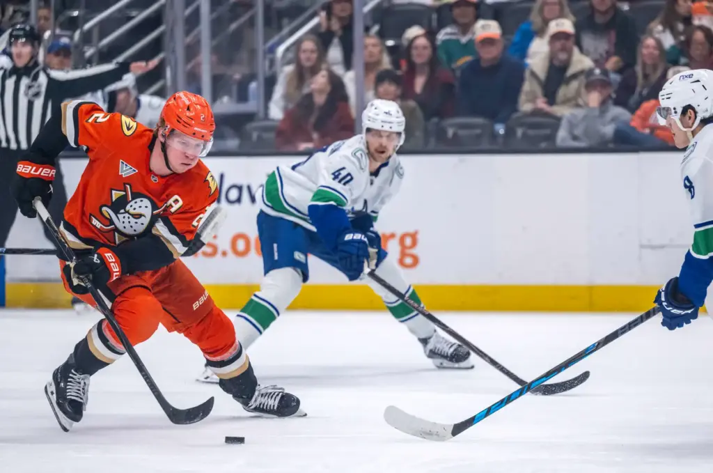 The Ducksâ Jackson LaCombe, left, controls the puck during the...