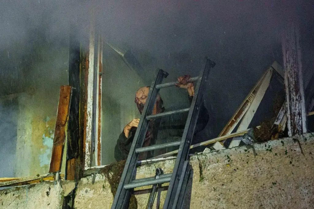 Leonid, an injured local resident, waits for rescuers on his balcony.