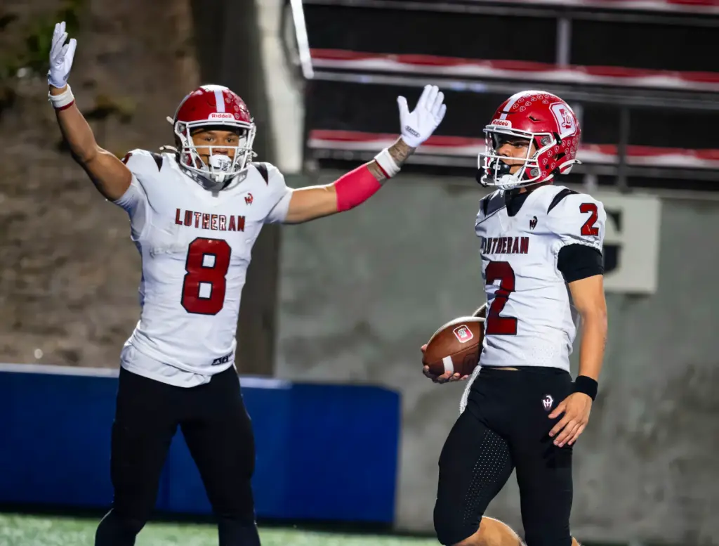 Orange Lutheran quarterback Reagan Toki, right, scores a touchdown against...
