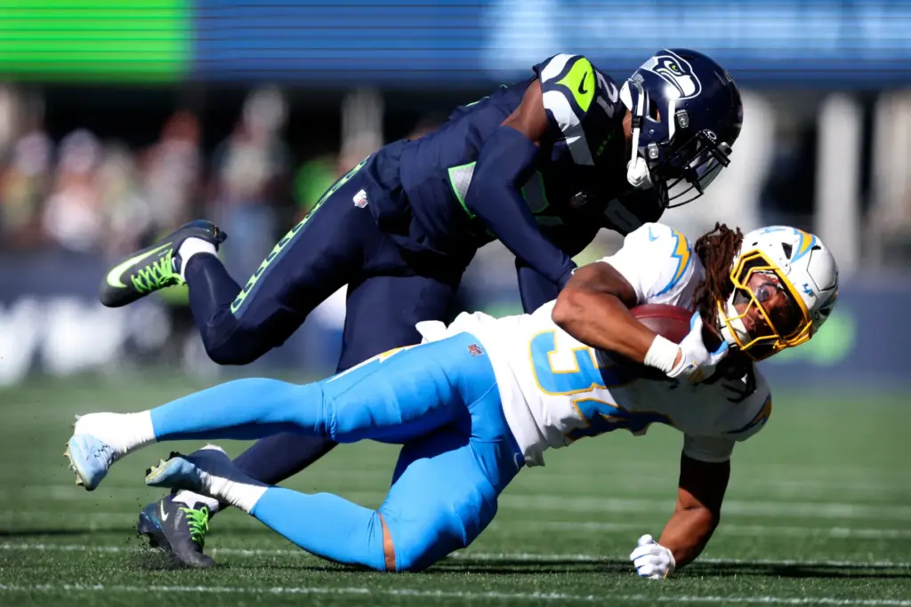 Chargers running back Keaton Mitchell (34) is tackled by Seattle...