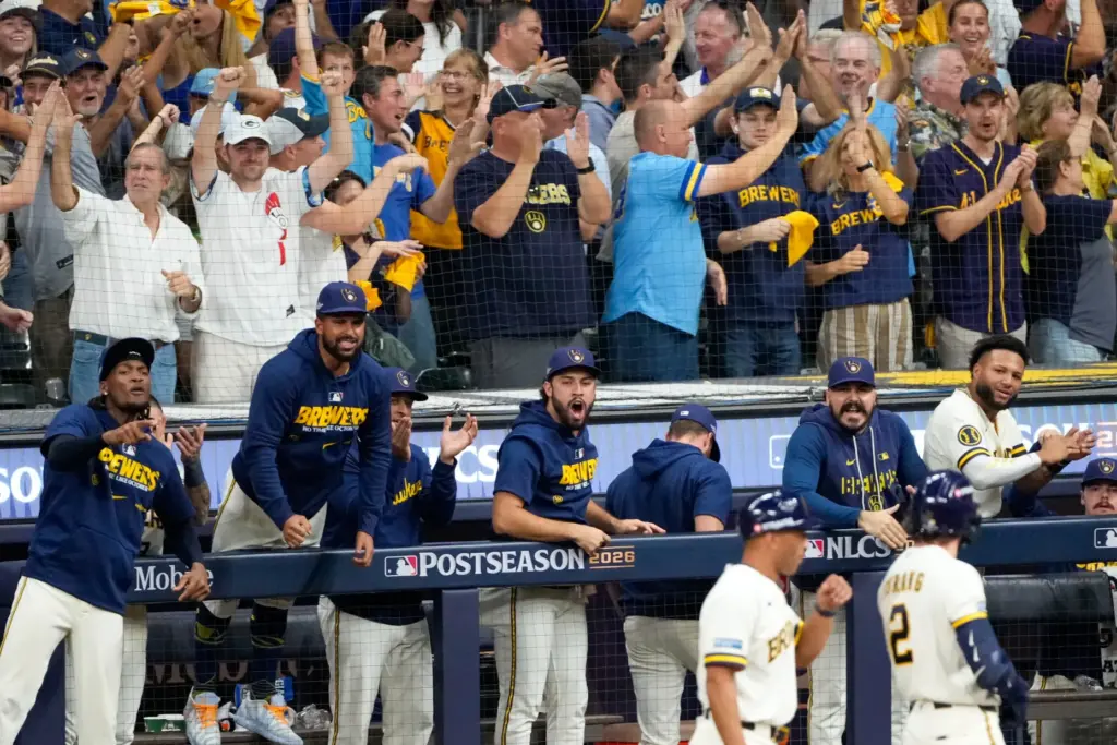 Milwaukee Brewers players and fans cheer during the eighth inning...