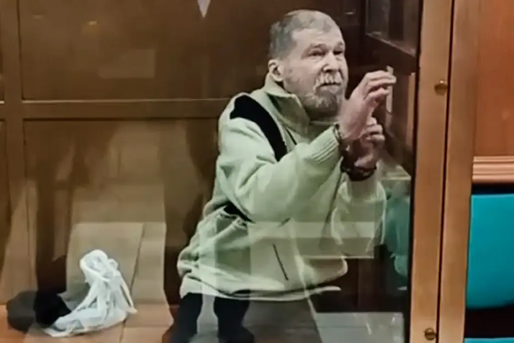 Stephen Hubbard stands in a glass cage during a session in the Moscow City court.