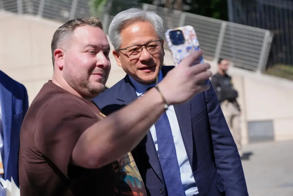 Mike Tannenbaum, of Fairfax, Va., takes a photo with Nvidia CEO Jensen Huange.