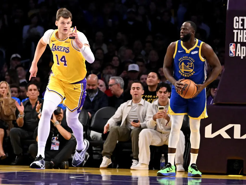 Lakers center Walker Kessler, left, gestures as he runs back...