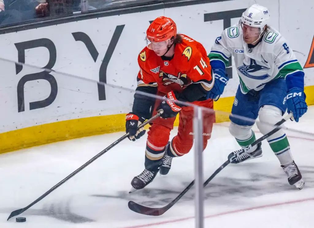 The Ducksâ Drew Helleson, left, controls the puck as the...