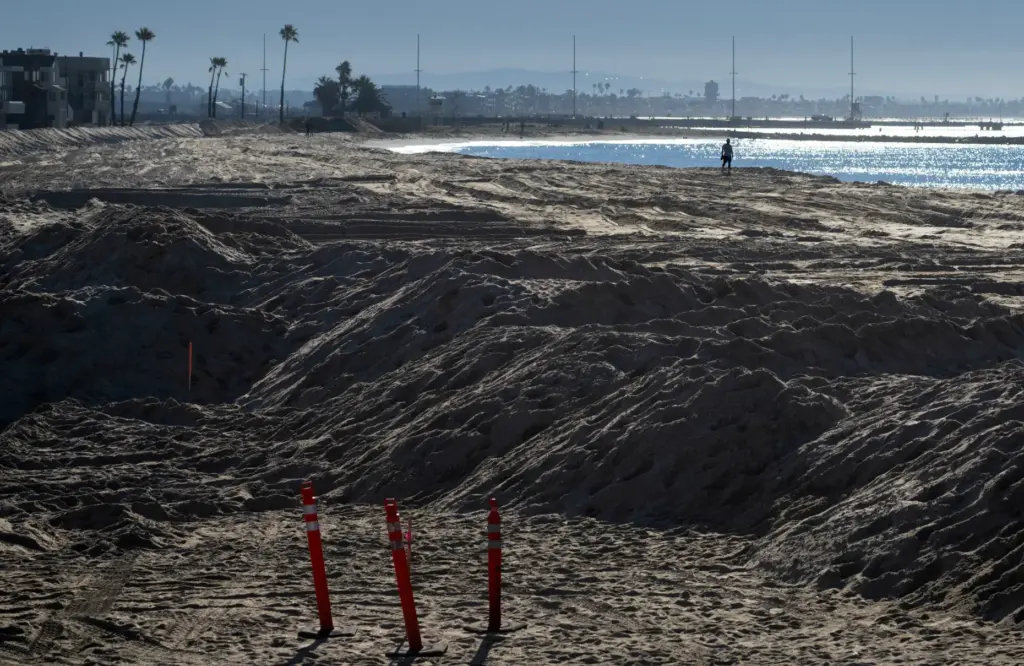Sand berms are in place near homes in Seal Beach...