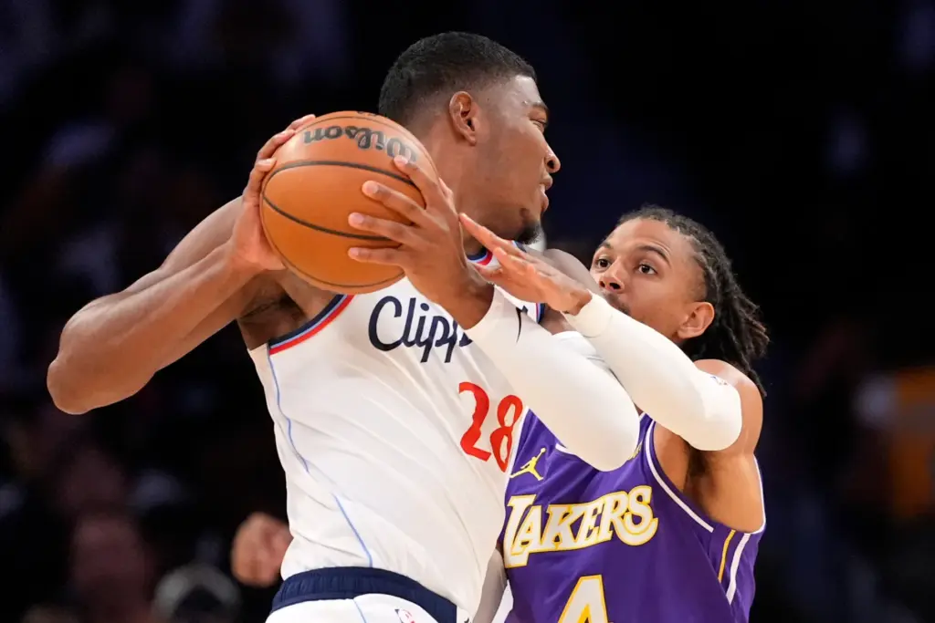 Clippers forward Rui Hachimura, left, shields the ball from Lakers...