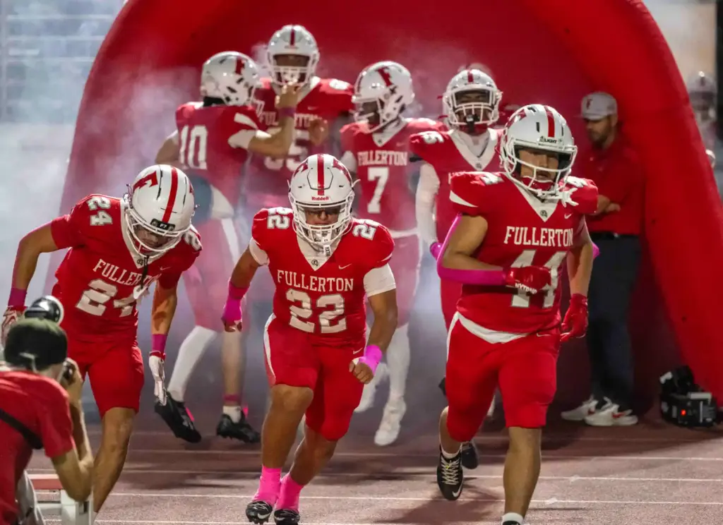 Fullerton players take the field for a Kappa League home...
