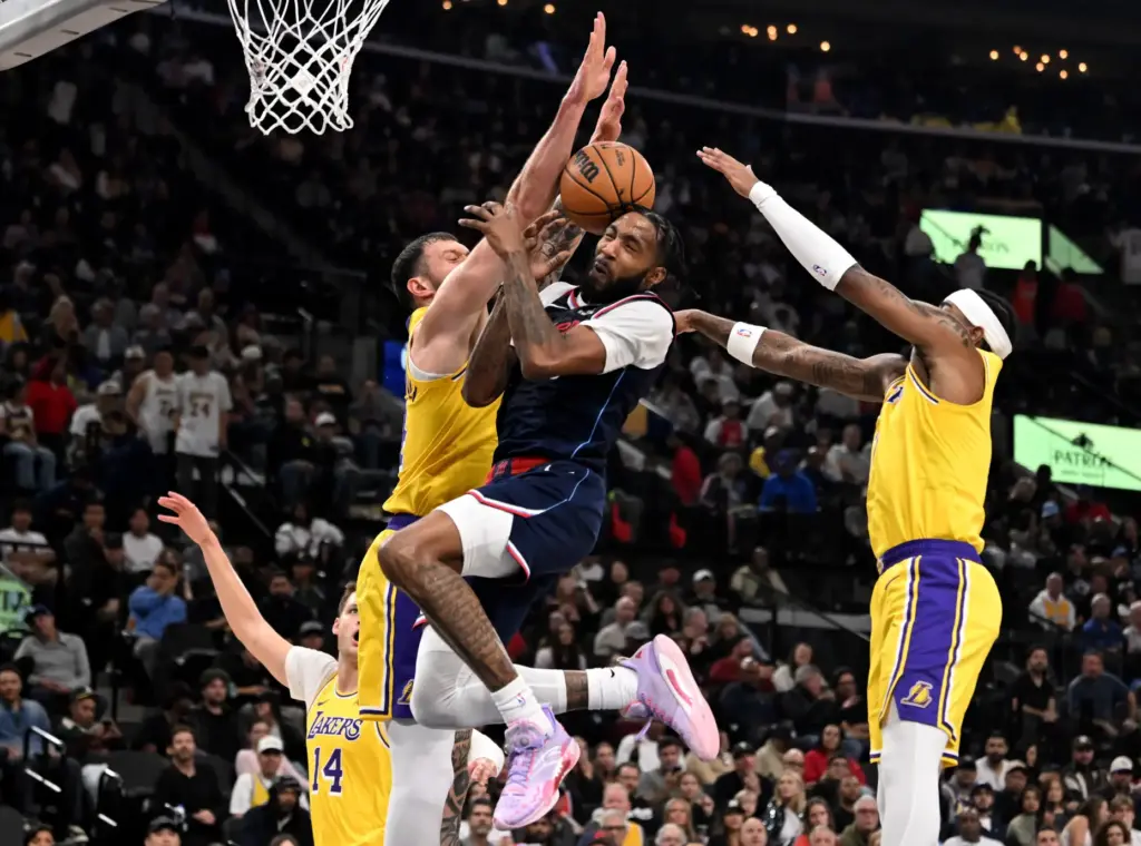 Clippers forward Derrick Jones Jr., middle, is fouled by Lakers...
