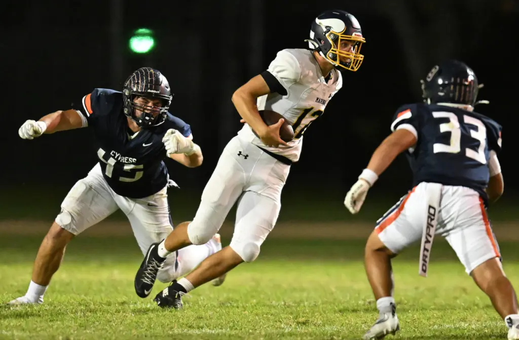 Quarterback Maverick Coverick #12 of Marina runs the ball in...