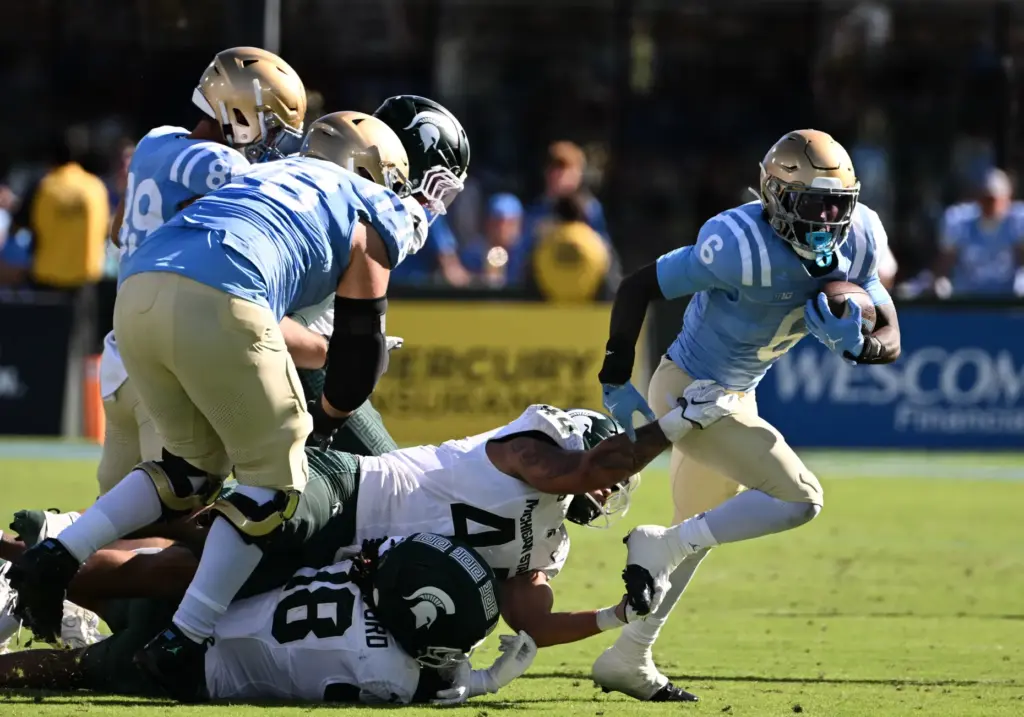 UCLA running back Anthony Woods (6) runs for yardage against...