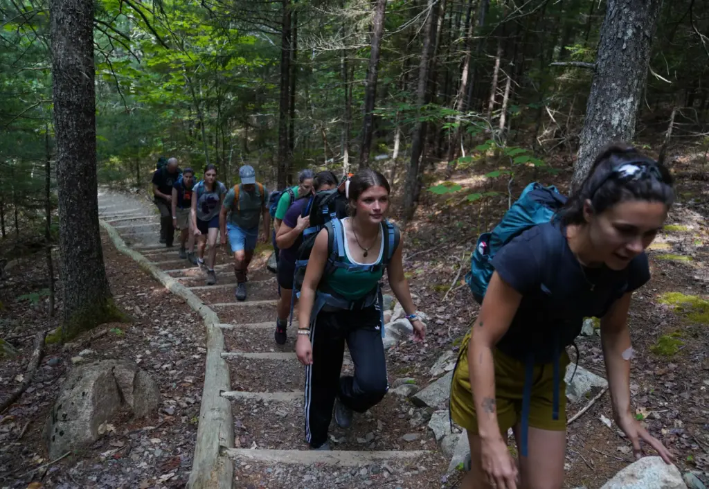 Volunteers carry soil to the summit of Sargent Mountain while...