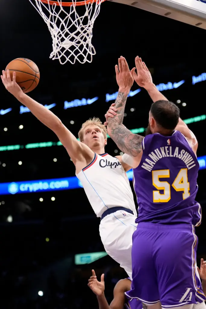 Clippers guard Gradey Dick, left, shoots as Lakers forward Sandro...